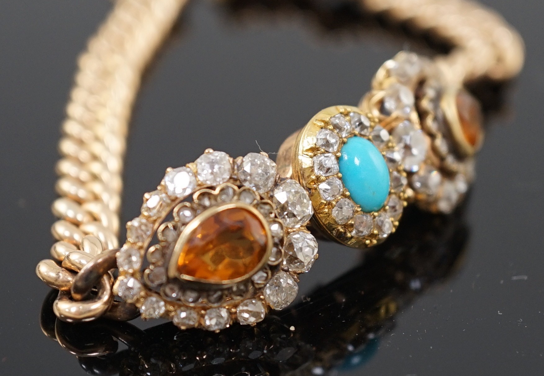 An Edwardian 15ct gold, citrine, turquoise and diamond set triple cluster set curblink bracelet